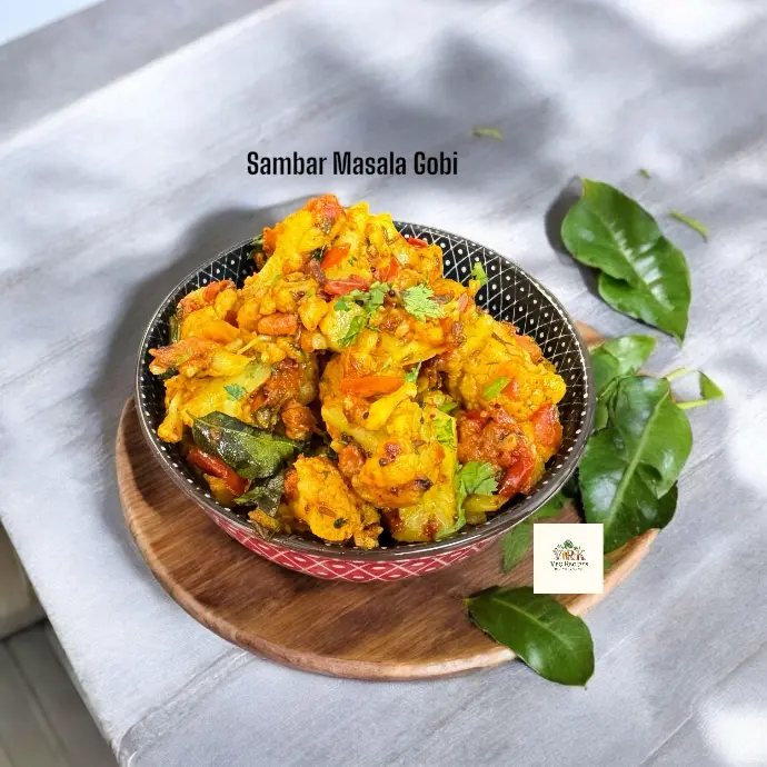 Cauliflower florets cooked in flavorful South Indian sambar masala, garnished with curry leaves and served as a dry sabzi