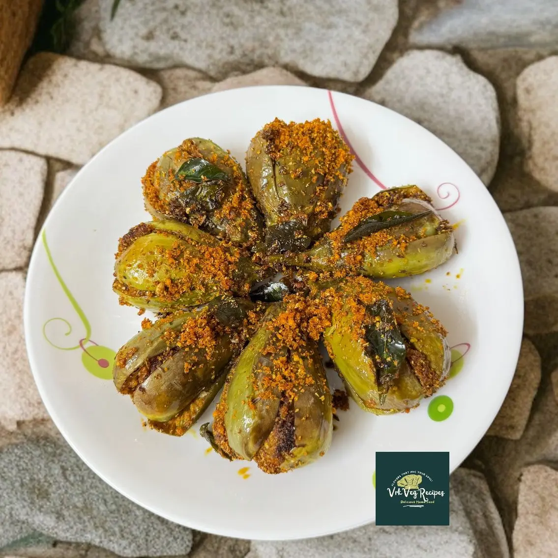 Stuffed brinjals cooked with aromatic dry masala powder made of coconut, garlic, and spices, served hot with rice.
