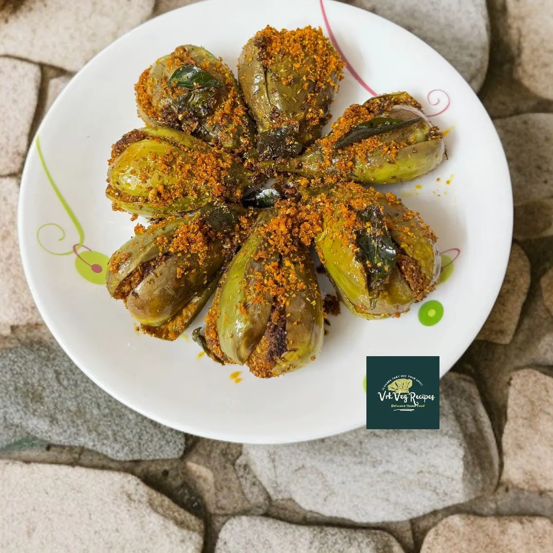 Stuffed brinjals cooked with aromatic dry masala powder made of coconut, garlic, and spices, served hot with rice.