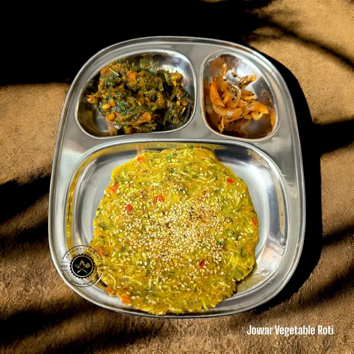 Spiced jowar flatbread packed with veggies like bottle gourd and carrot, served fresh and hot with dip.