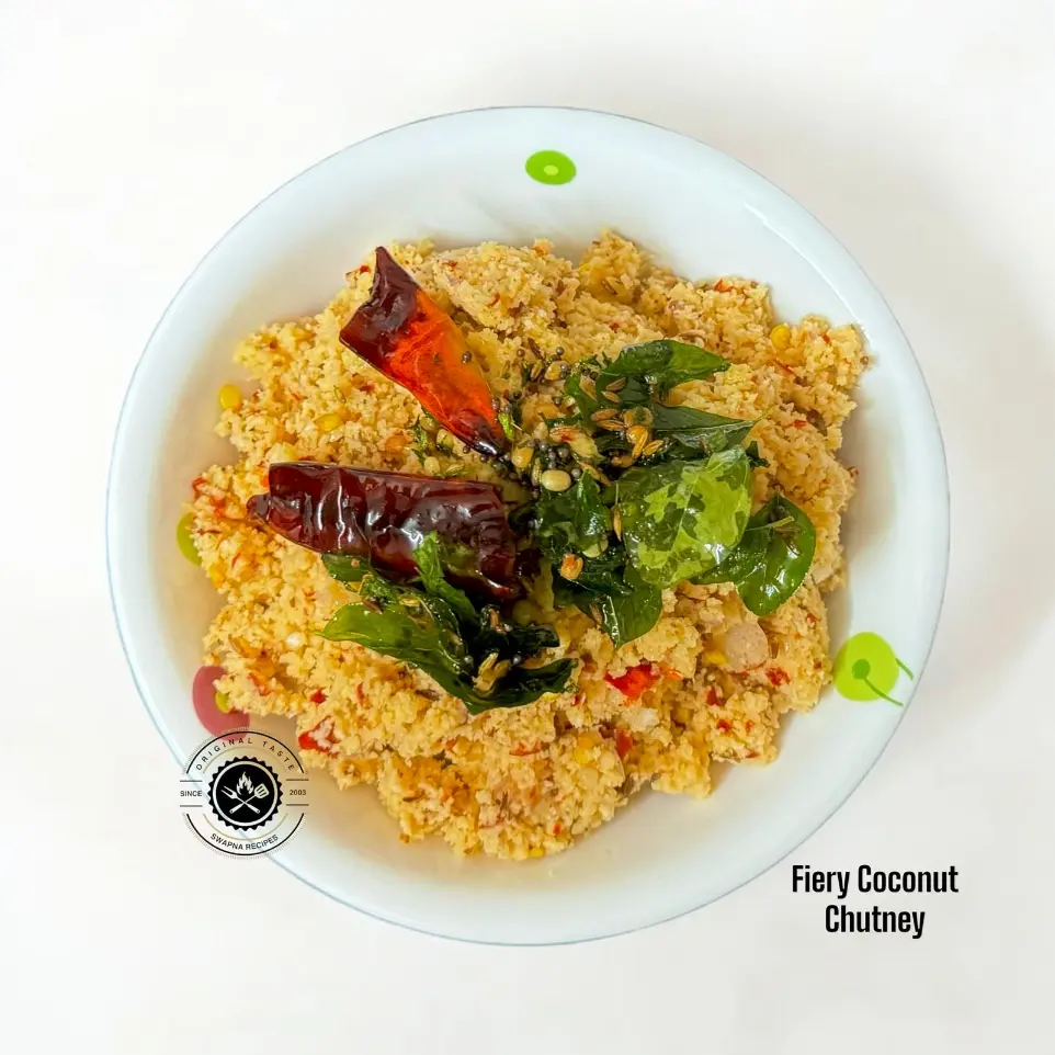 Spicy Red Chilli Coconut Chutney for Dosa & Rice Hot and spicy coconut chutney with red chillies, black pepper, and crispy tempering served in a rustic bowl