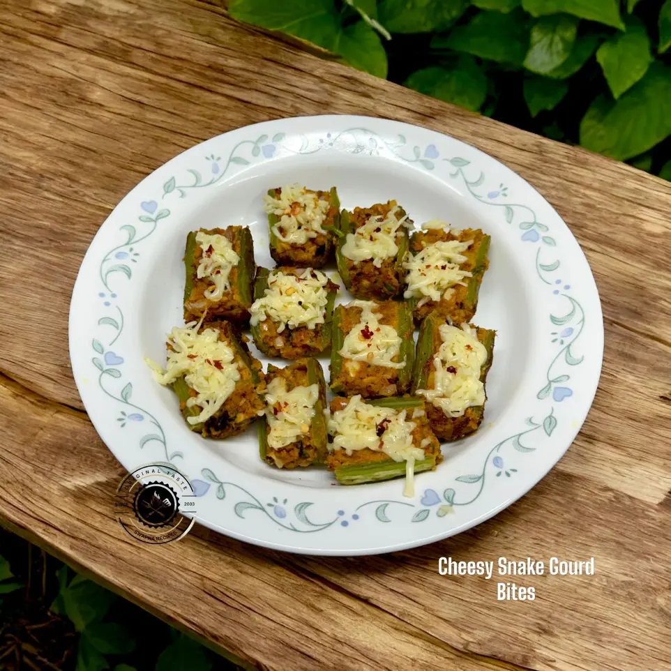 Cheesy Stuffed Snake Gourd Boats Recipe Cheesy stuffed snake gourd boats filled with spicy sesame coconut masala and topped with chili flakes and melted cheese.